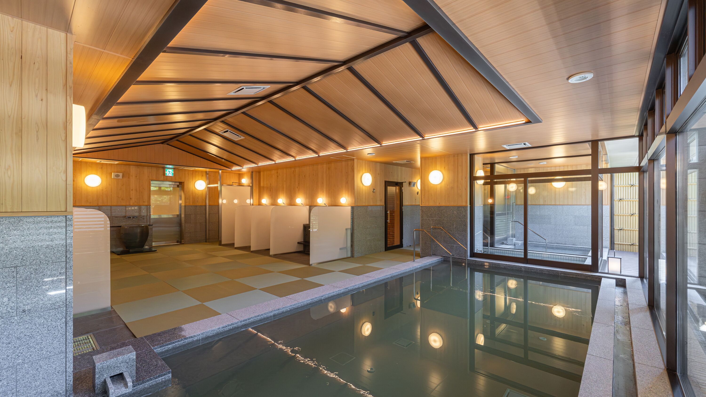 A modern indoor pool area with a checkered floor, wooden panel walls, and a glass enclosure.