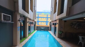 Una piscina interior estrecha con vista despejada a un edificio colorido al fondo.