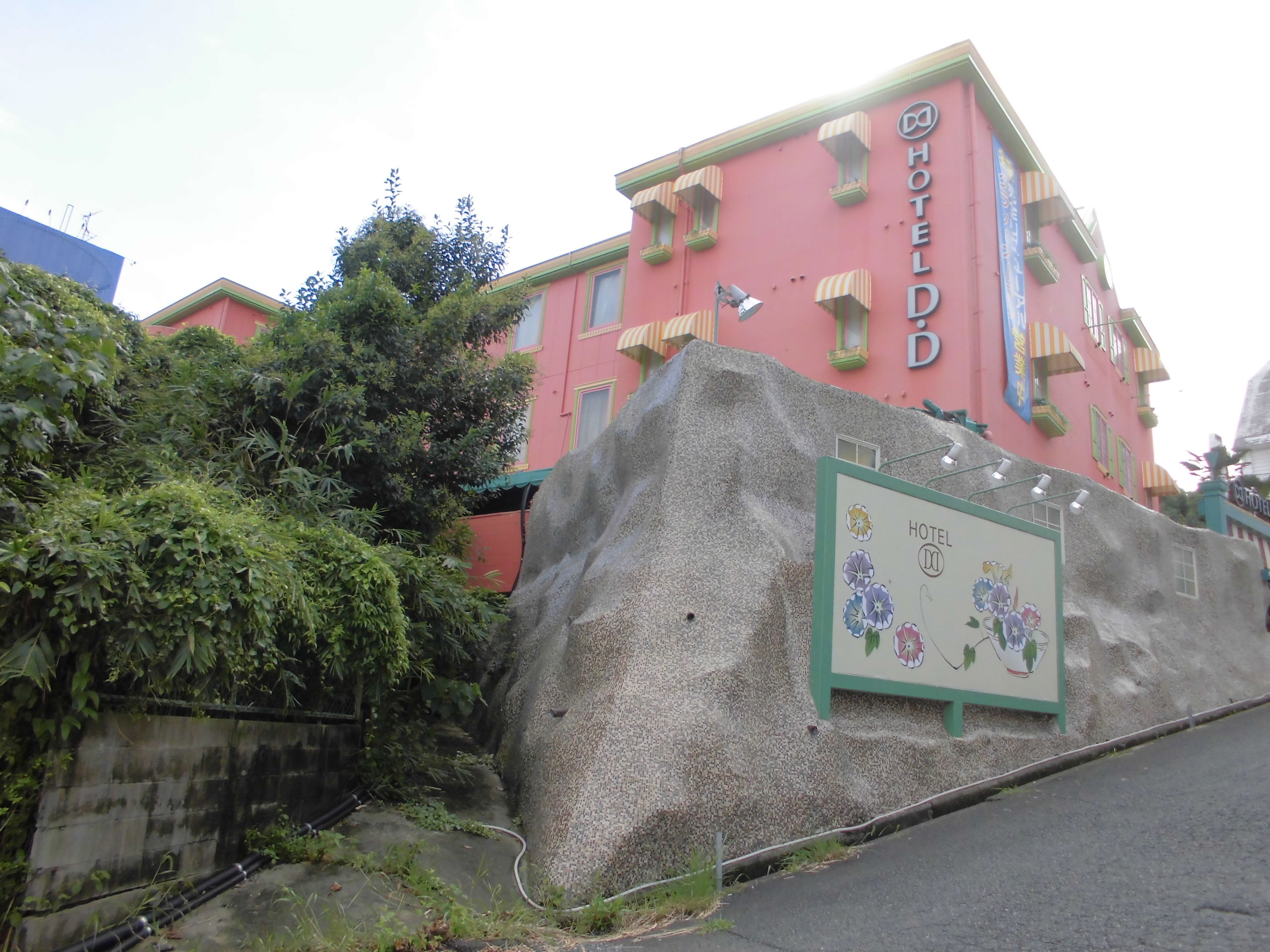 Un edificio rosa con un letrero que dice 'HOTEL D'.