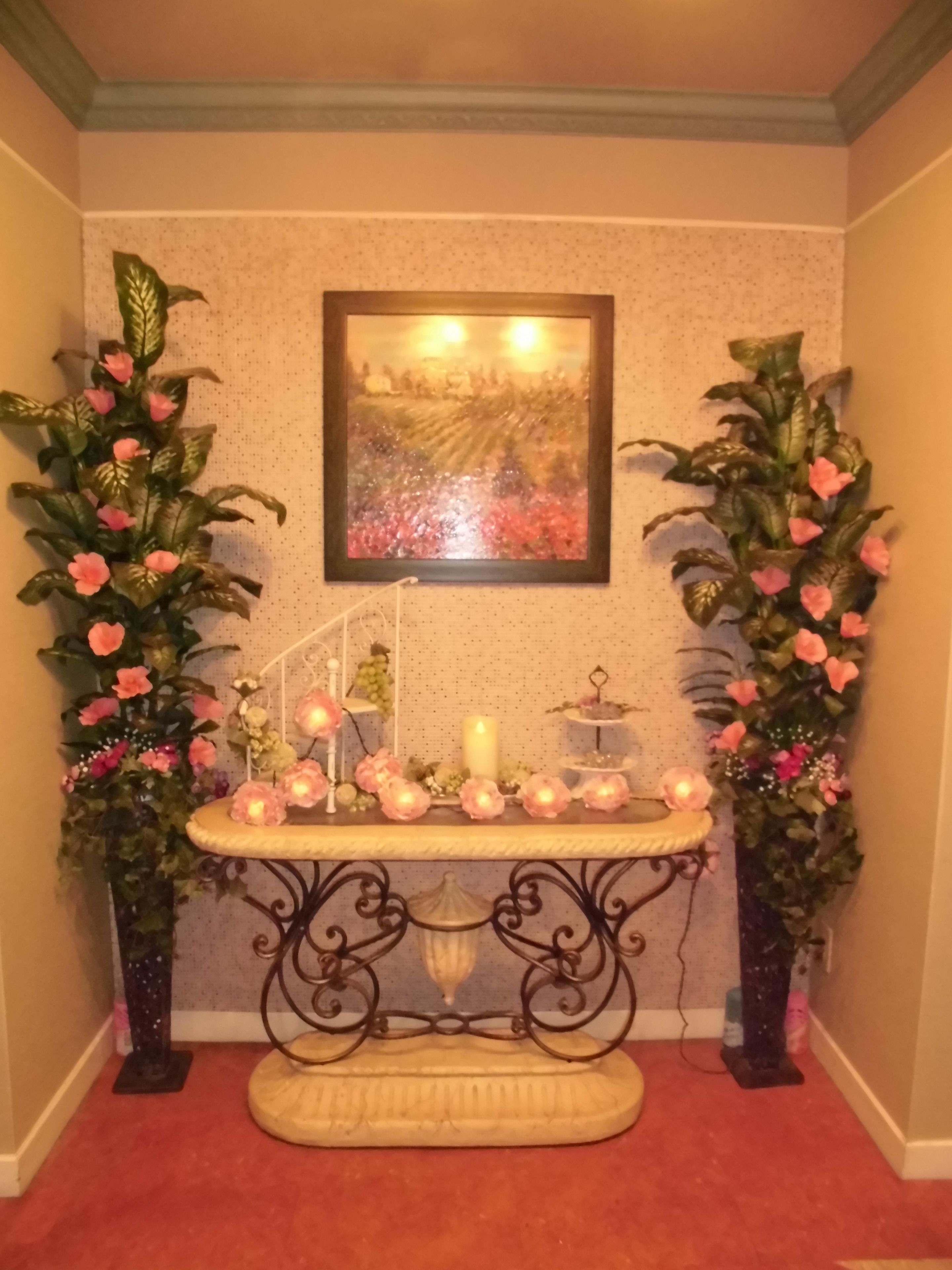 A room with a decorative altar, candles, and floral arrangements.