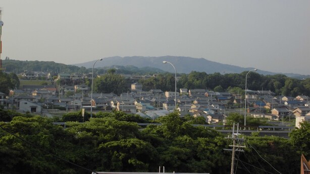 A residential area with houses and streetlights, surrounded by greenery and mountains in the background. - Hotel D.D Kashiba (Kashiba)