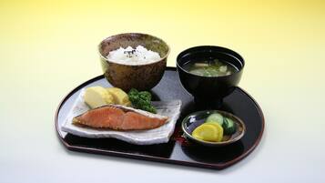Ein Tablett mit Lachs, Reis, Suppe und einer kleinen Schale eingelegtes Gemüse.