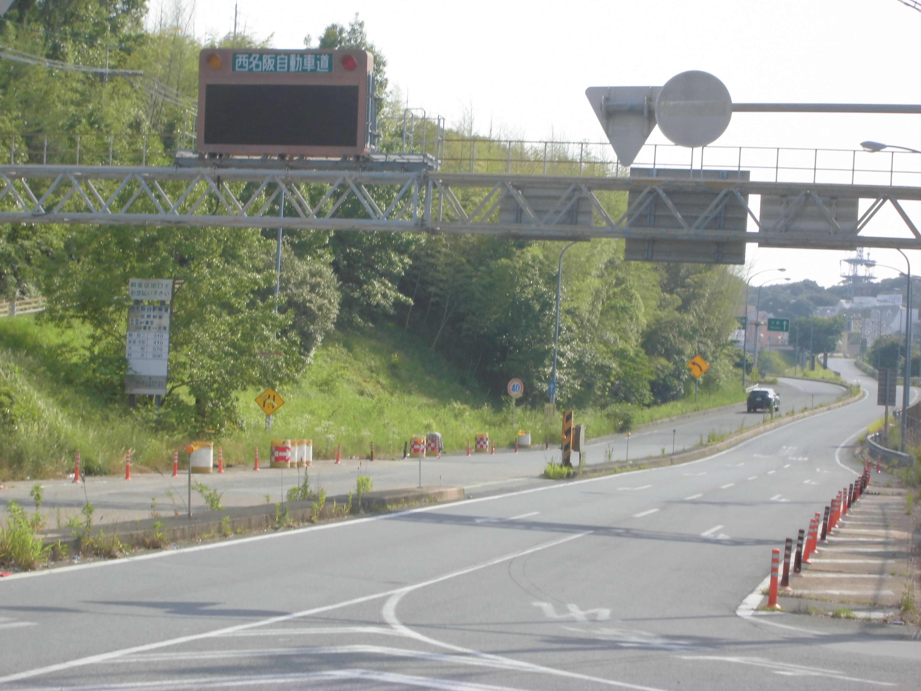 Uma autoestrada com várias faixas, cones de trânsito e uma passarela para pedestres.