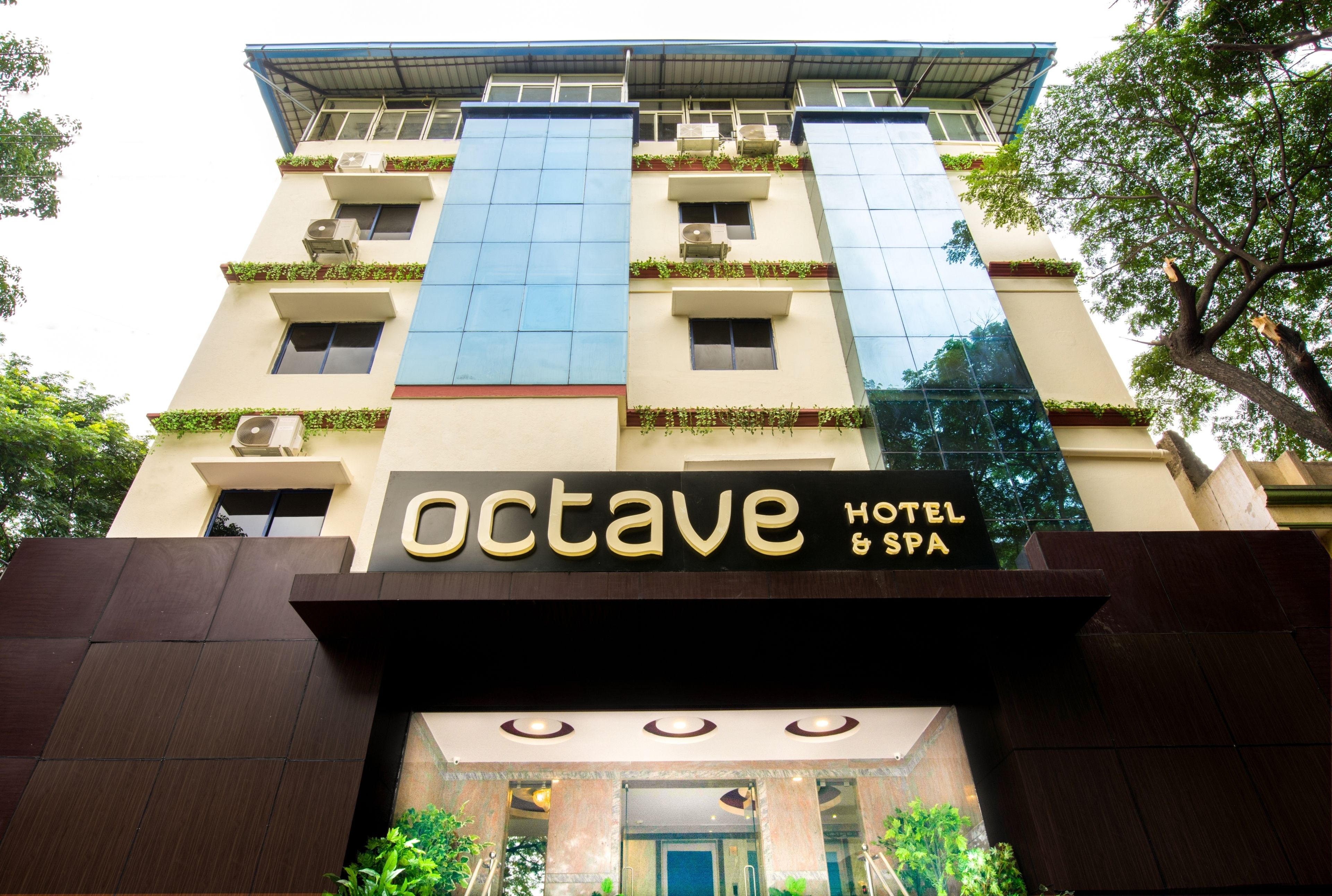 The exterior of the Octave Hotel & Spa, featuring a modern facade with large windows and air conditioning units.