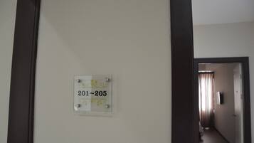 A hallway with a sign indicating room numbers 201-205.