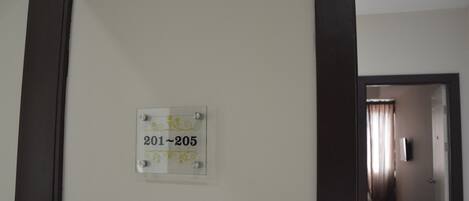 A hallway with a sign indicating room numbers 201-205.