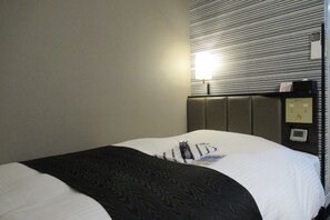 A hotel room with a bed, a headboard, a bedside table, and a wall-mounted control panel. - APA Hotel Miyazaki Miyakonojo Station (Miyakonojo)