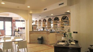 A restaurant interior with tiled flooring, a counter with a cash register, and shelves with bottles and glasses. - Hotel Stazione sul lago di Iseo (Paratico)