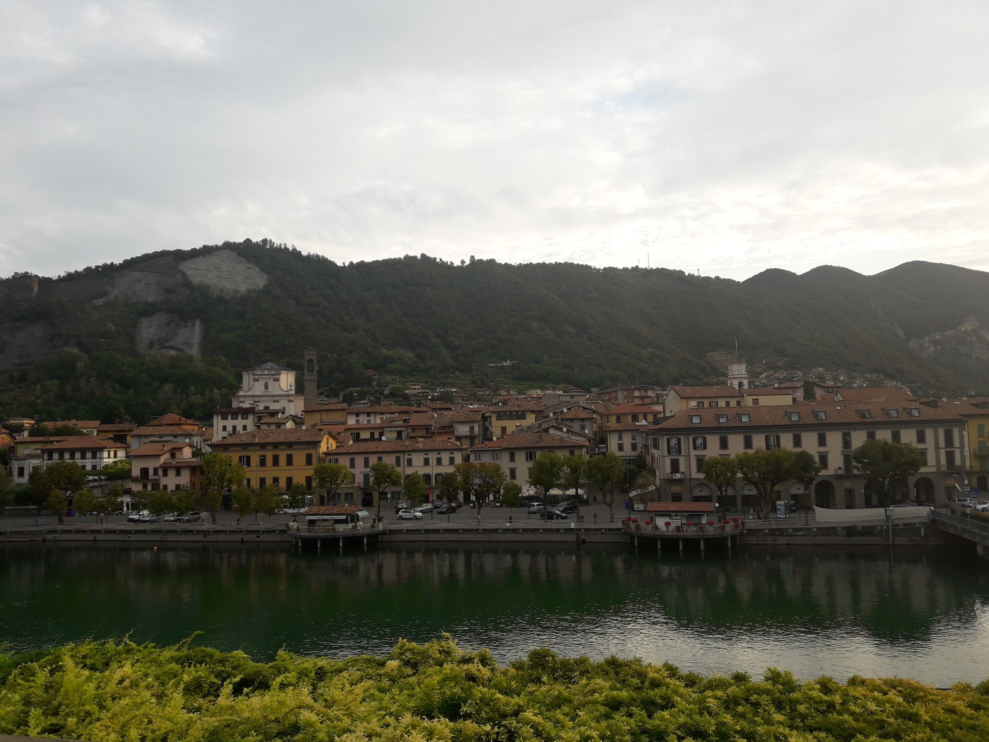 A riverside town with historic buildings, a prominent church tower, and a bridge.