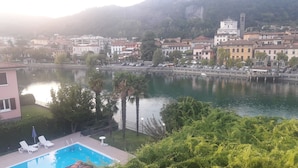 A residential area with a swimming pool, a dock, and a mountain backdrop. - Hotel Stazione sul lago di Iseo (Paratico)