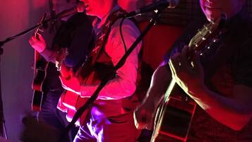 Una banda actuando en el escenario con instrumentos musicales y un micrófono.