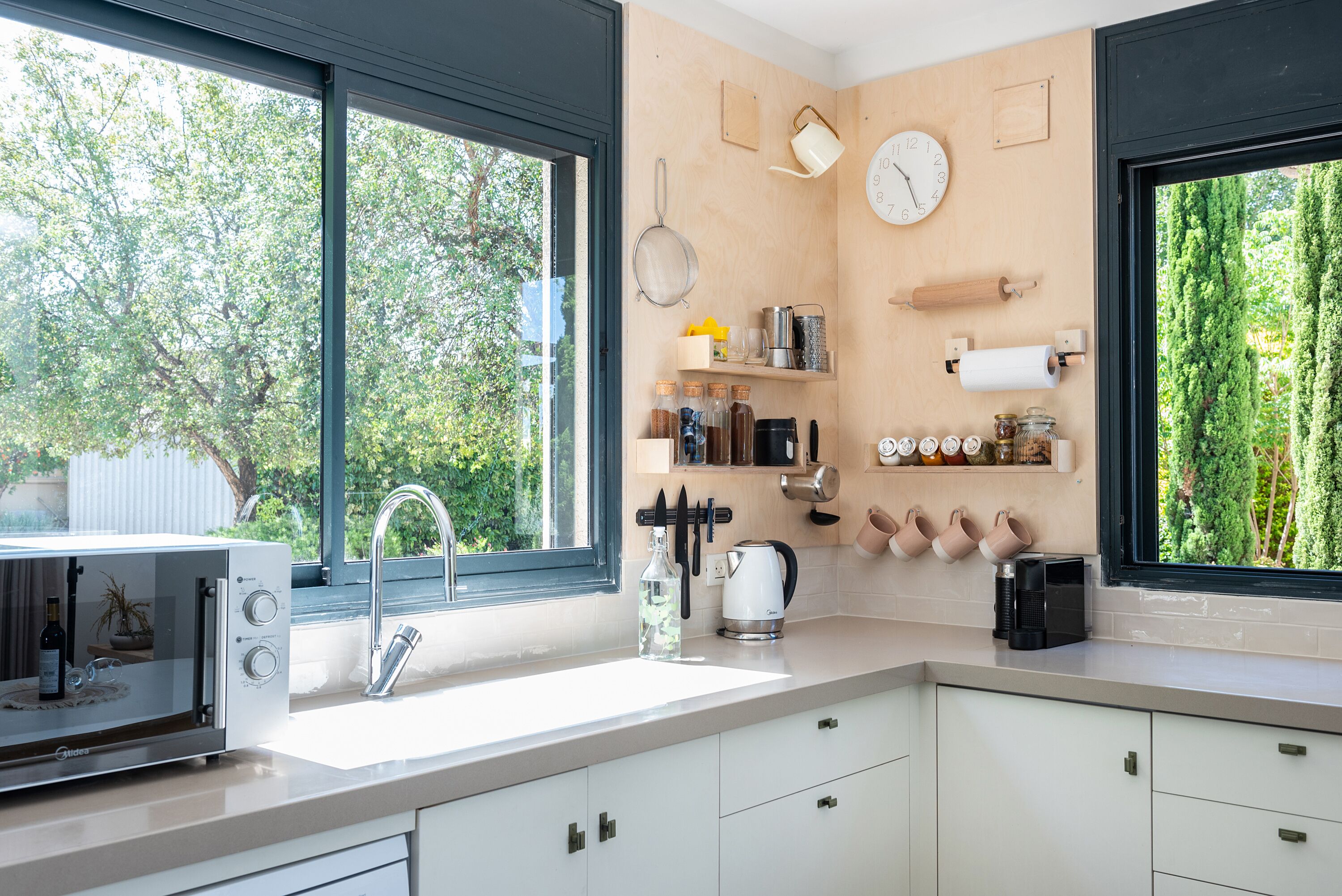 A modern kitchen with a large window, a sink, and various kitchen appliances.