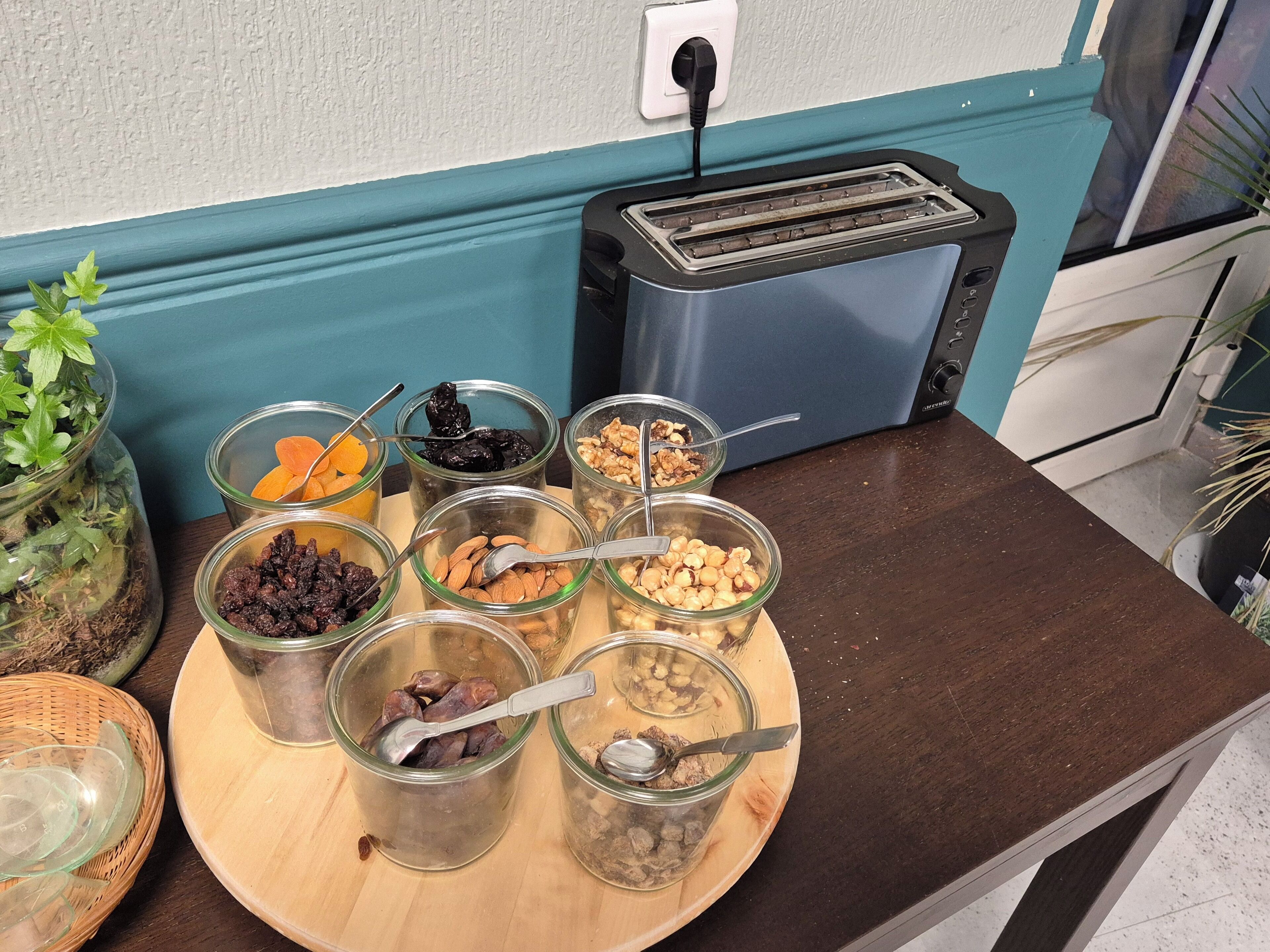 A kitchen counter with various food items in jars and a toaster.