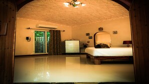 Une chambre d’hôtel avec un lit, une commode, un miroir et un ventilateur de plafond.