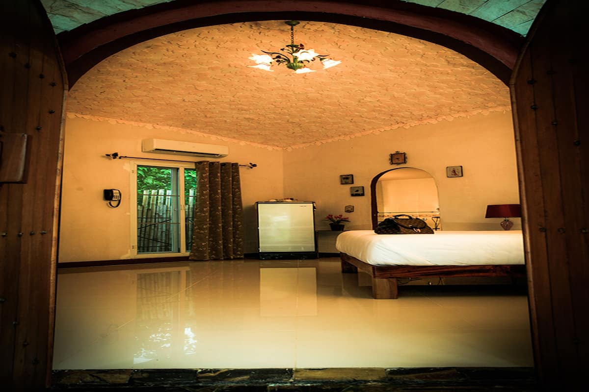 A hotel room with a bed, a dresser, a mirror, and a ceiling fan.