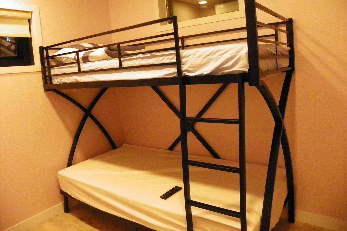 Una litera con ventana sobre la cama superior.