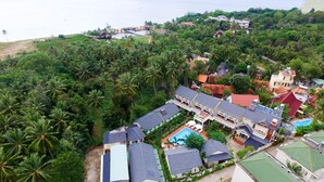 An aerial view of a coastal residential area with multiple houses, a swimming pool, and lush greenery. - Blue Paradise Resort (Phu Quoc)