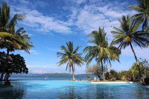 Una piscina al aire libre, sillones reclinables de piscina