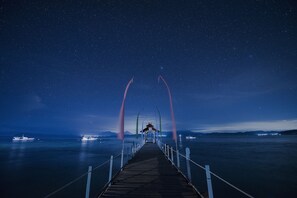 A pier extending into a body of water under a starry night sky. - Gangga Island Resort & Spa (Pulau Gangga)