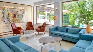Una sala de estar moderna con sofás azules, sillones de cuero y una mesa de centro.