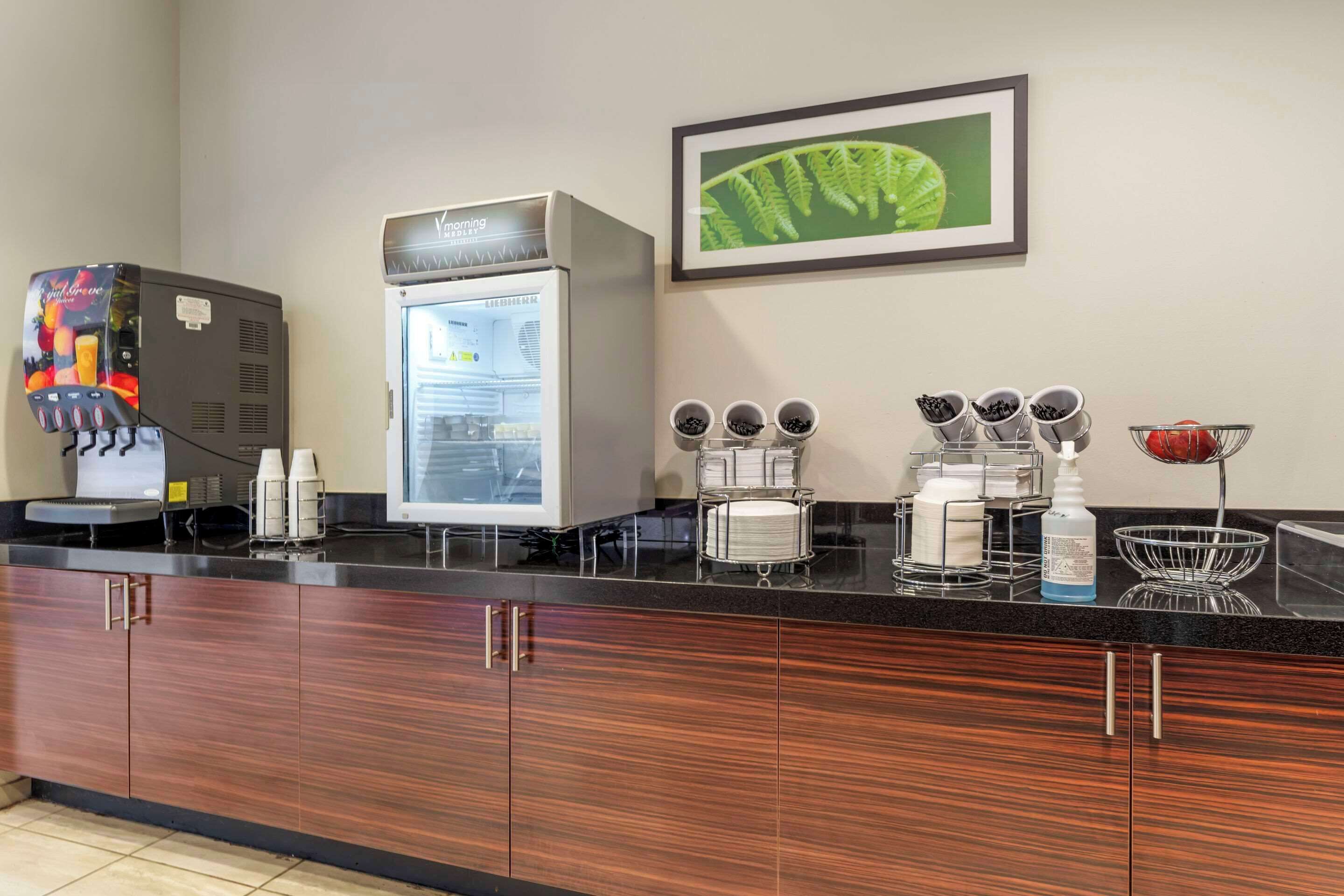 Uma cozinha moderna com frigorífico, máquina de café e diversos eletrodomésticos.