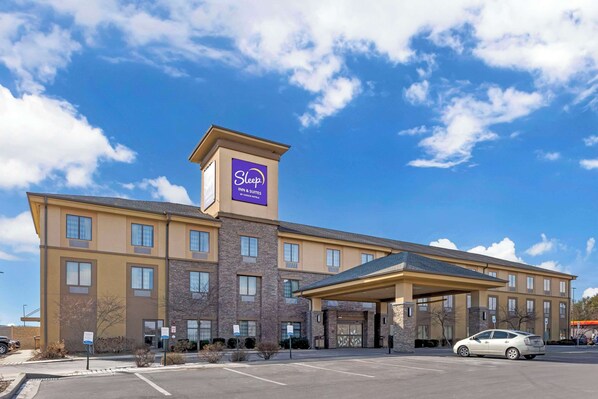A Sleep Inn & Suites hotel with a prominent purple sign, a covered entrance, and a parking lot. - Sleep Inn & Suites Cumberland - LaVale (Cumberland)