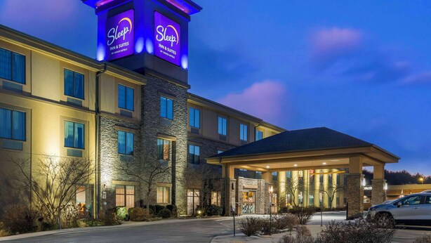 A Sleep Inn & Suites hotel with a prominent tower sign, a covered entrance, and a parking lot. - Sleep Inn & Suites Cumberland - LaVale (Cumberland)