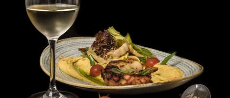 A plate of food with a glass of white wine.