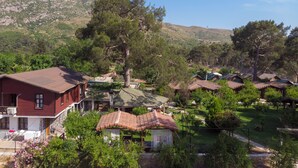 A rural village with traditional houses, a stone building, and a mountainous backdrop. - Koala Bungalows (Kumluca)