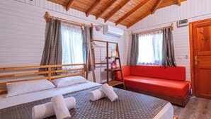 A wooden cabin with a loft-style bedroom, a red sofa, and a ladder. - Koala Bungalows (Kumluca)