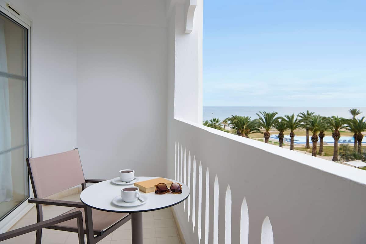 A balcony with a table and chairs, a pair of sunglasses, and a box of tissues.