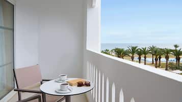 A balcony with a table and chairs, a pair of sunglasses, and a box of tissues.