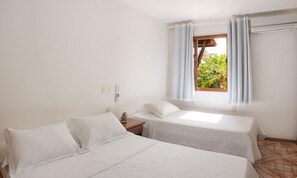 Una habitación con dos camas individuales, una ventana con cortinas, una mesita de noche y vistas al exterior.