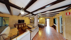 A spacious living room with a fireplace, a television, and a dining area with chairs and a table. - Casa Rural La Majada Palentina (Santibanez de la Pena)