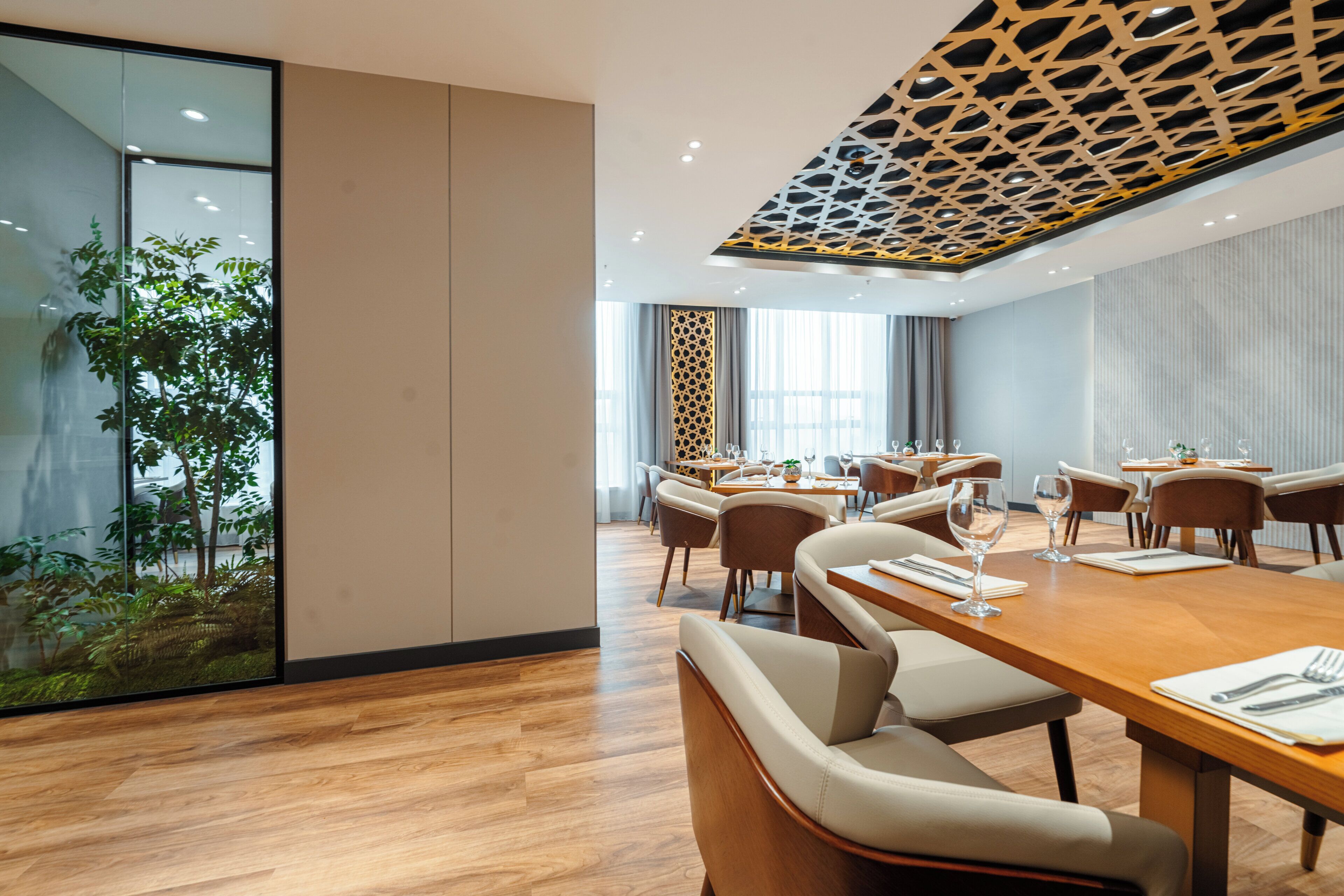 A modern conference room with a wooden table, chairs, and a glass partition.