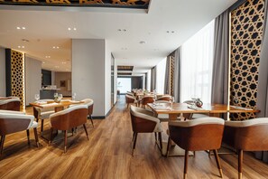 A hotel dining area with wooden flooring, modern furniture, and large windows. - Holiday Inn Ulaanbaatar by IHG (Ulaanbaatar)