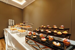 A buffet table with various food items and a beverage station.