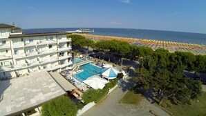 Un hôtel doté d’une piscine, de parasols de plage et offrant une vue sur la mer.