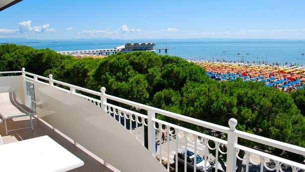 Un balcon avec vue sur une plage et une jetée.