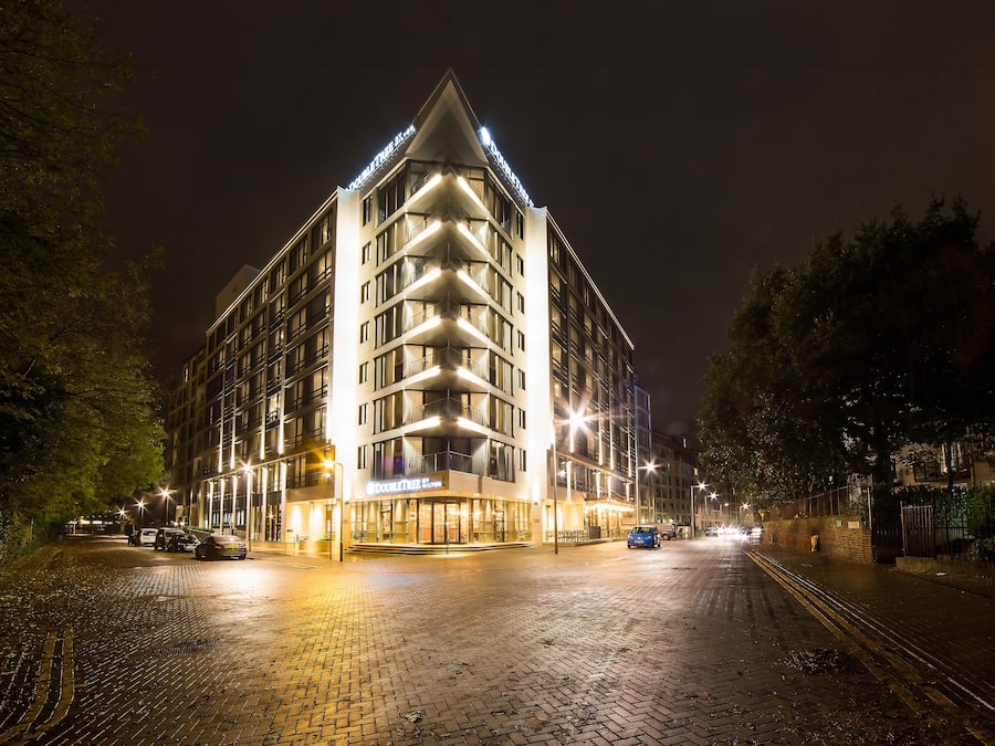Un hotel amb un disseny modern, amb una entrada cantonera destacada i una façana ben il·luminada.