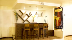 Una zona de bar con mobiliario de madera y un mural en la pared.