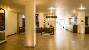 Un vestíbulo espacioso con una escalera, una recepción y una zona de cocina.