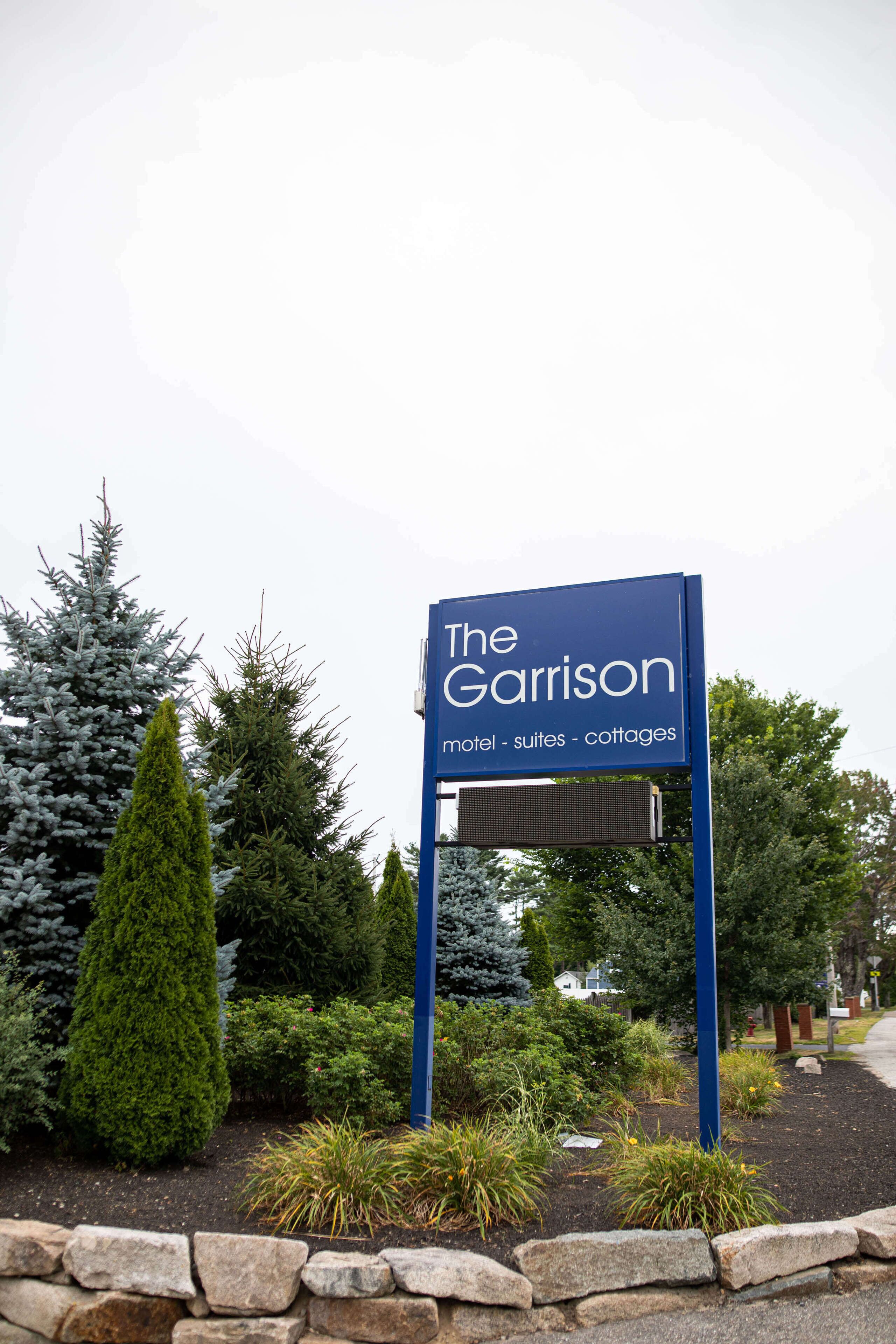 Señal del motel The Garrison, que indica que ofrece habitaciones de motel, suites y cabañas.