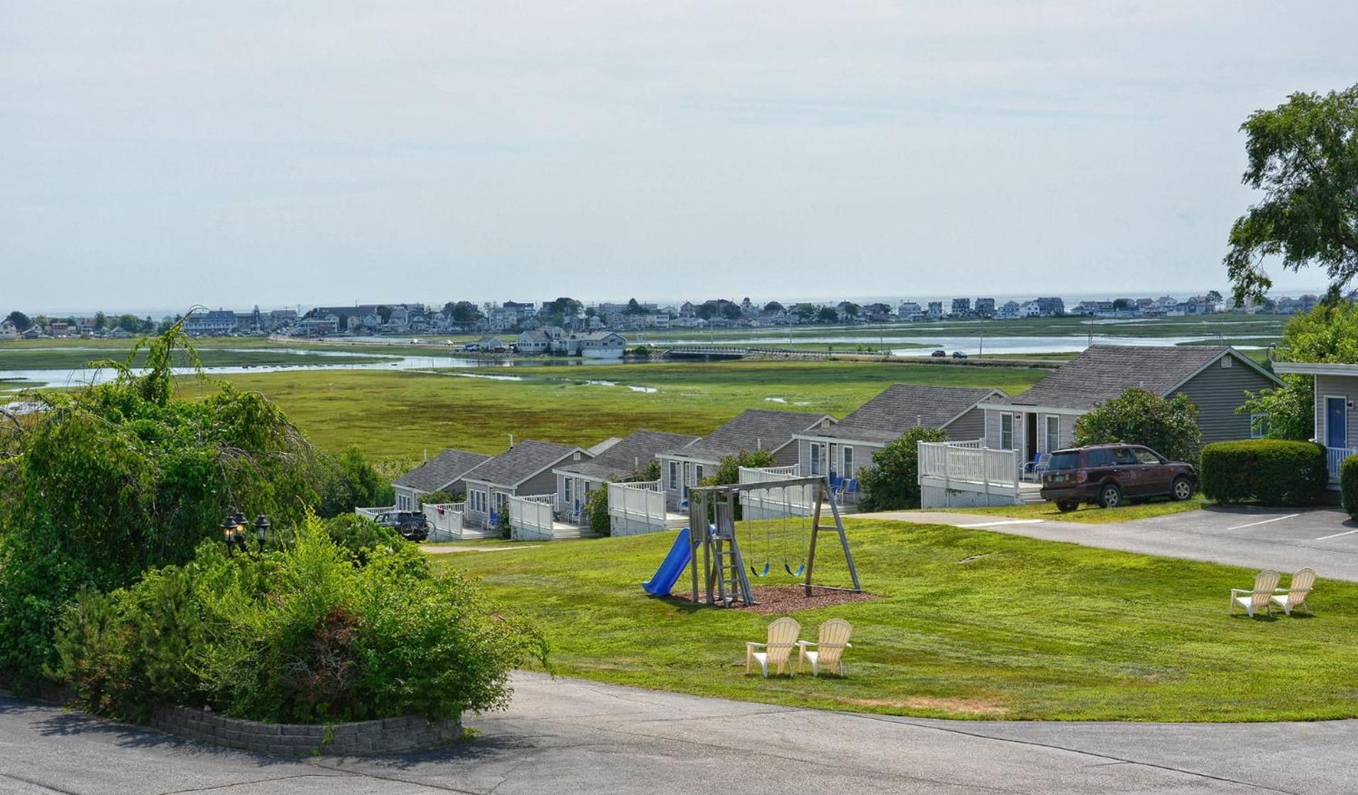 A residential area with houses, a playground, and a view of the water.