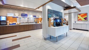A modern breakfast area with a counter displaying various food items and a chalkboard with messages. - Holiday Inn Express & Suites Carrollton West by IHG (Carrollton)