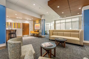 A hotel lobby with a sofa, chairs, a desk, and a large window. - Holiday Inn Express & Suites Carrollton West by IHG (Carrollton)