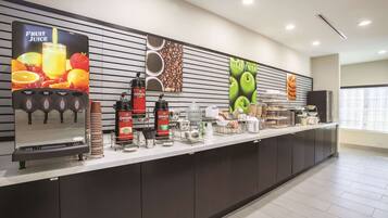 A self-service beverage station with various drink dispensers and a coffee machine.