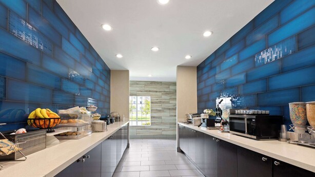A modern kitchen with a central island, built-in appliances, and a view to the outside. - La Quinta Inn & Suites by Wyndham Cullman (Cullman)