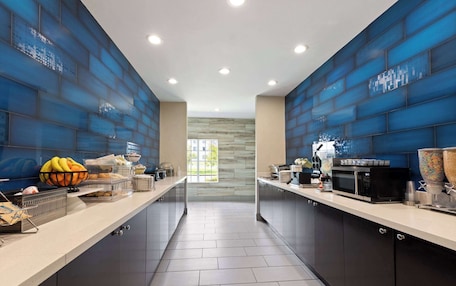 A modern kitchen with a central island, built-in appliances, and a view to the outside.