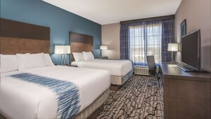 A hotel room with two beds, a desk with a TV, and a large window with curtains. - La Quinta Inn & Suites by Wyndham Cullman (Cullman)